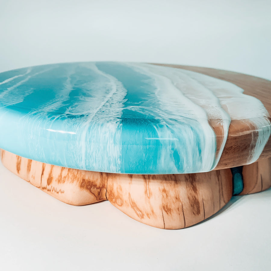 handmade round coastal cake stand with ocean epoxy art details with a smaller live edge epoxy stump as the base